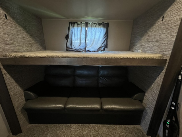 guest room has a davenport sofa couch under a hideaway top bunk